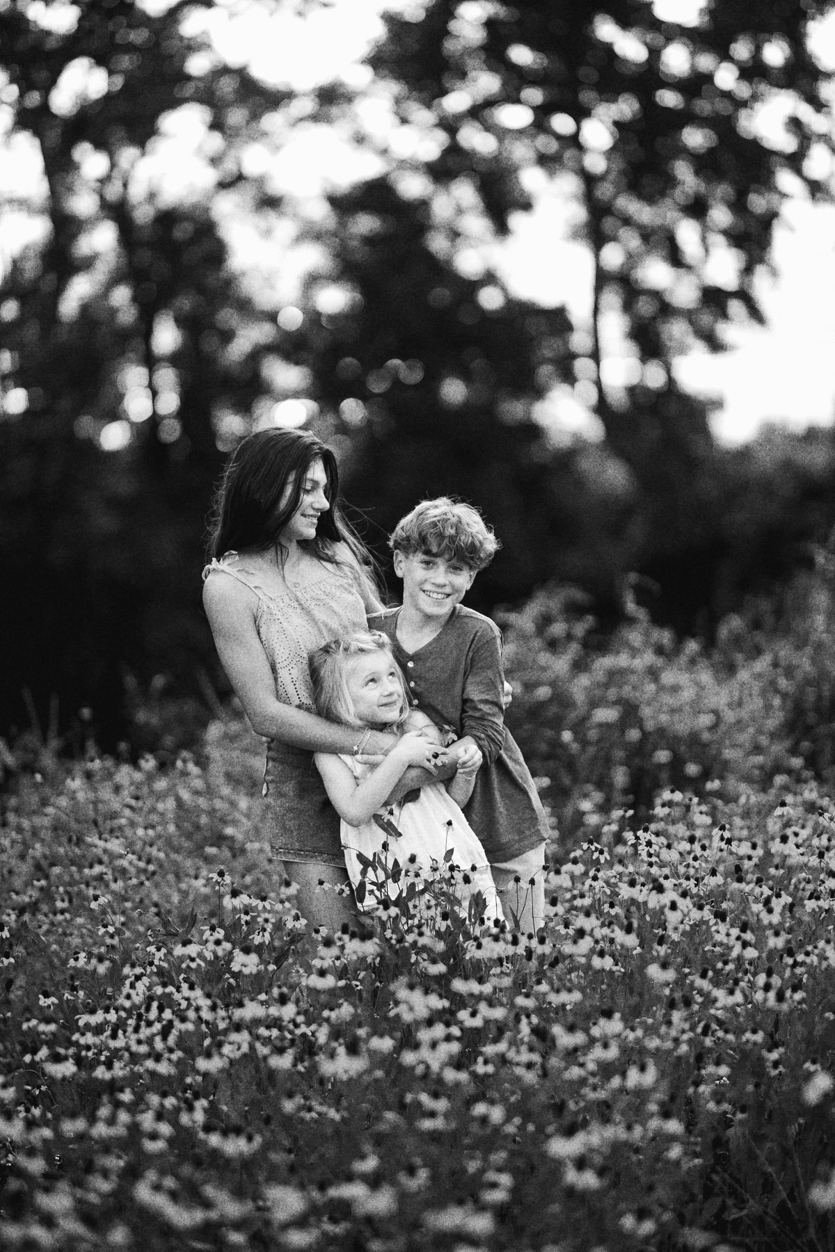 The three Lipari kids hugging in the wildflowers