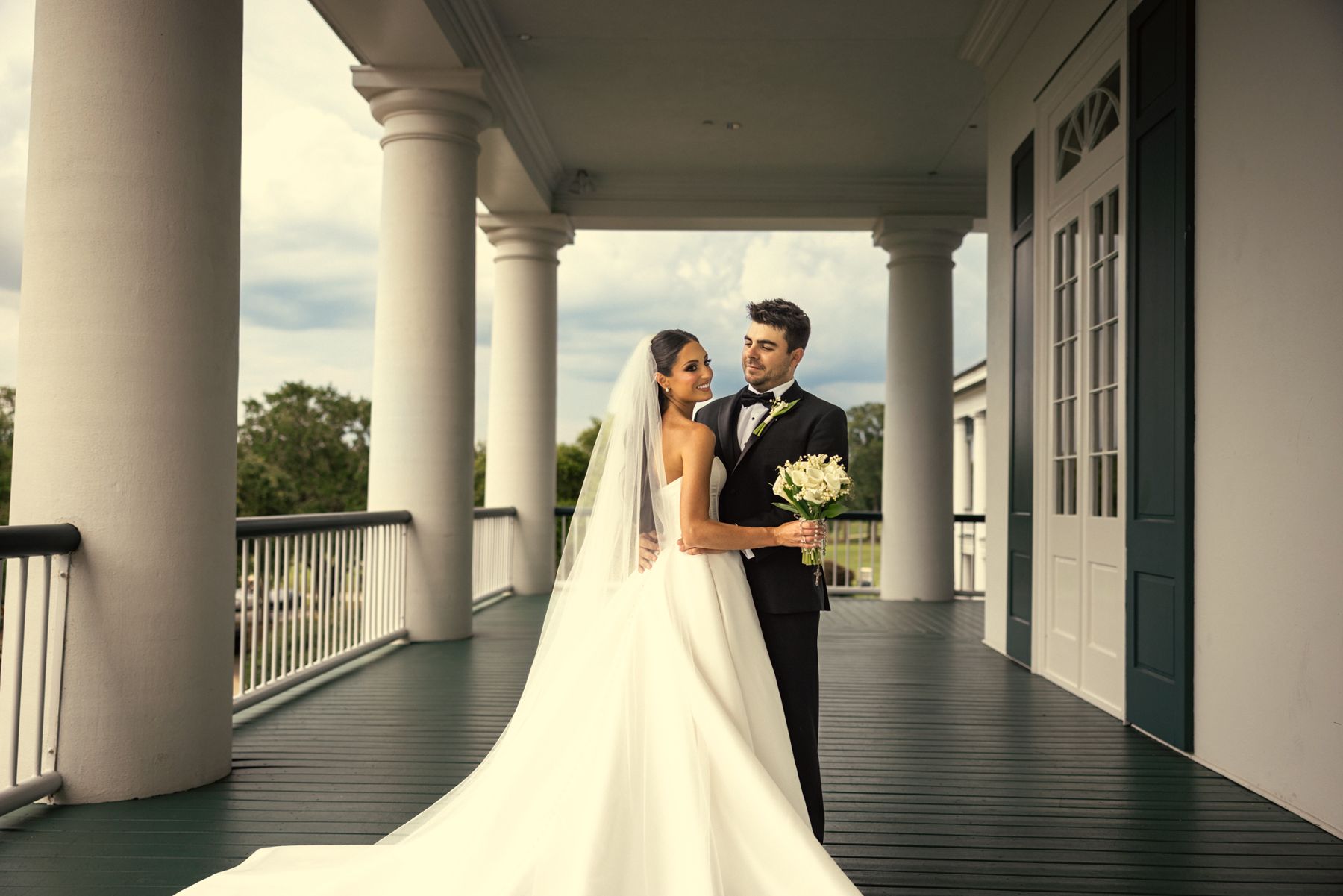Bride and groom on a columned porch